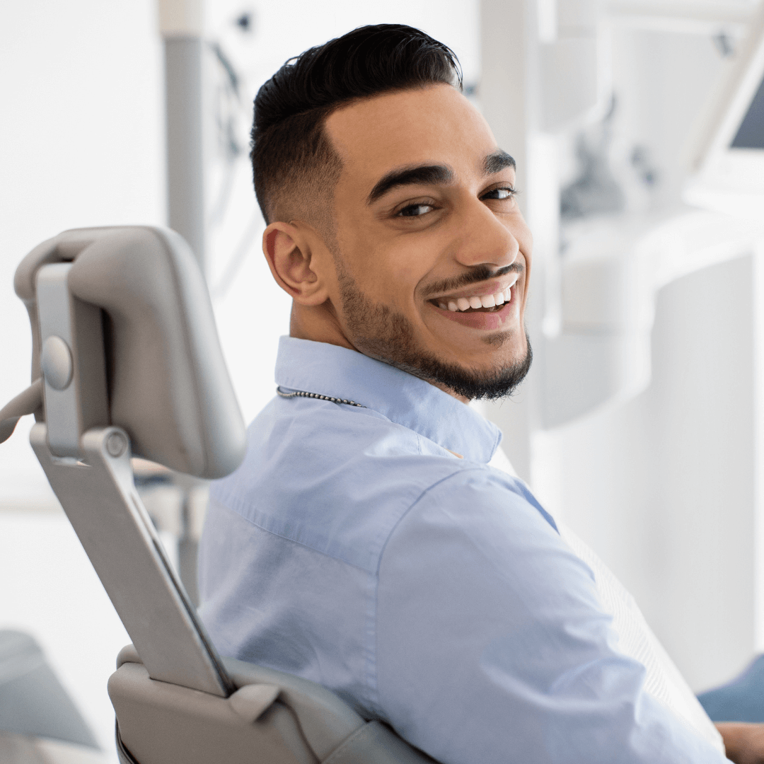 Male adult sitting in dentist chair.