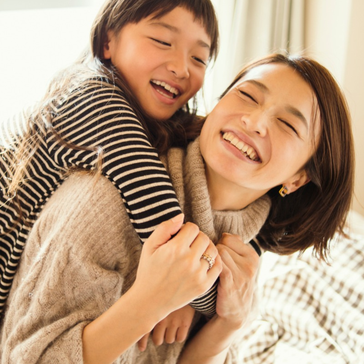 Mom playing with daughter on her back.