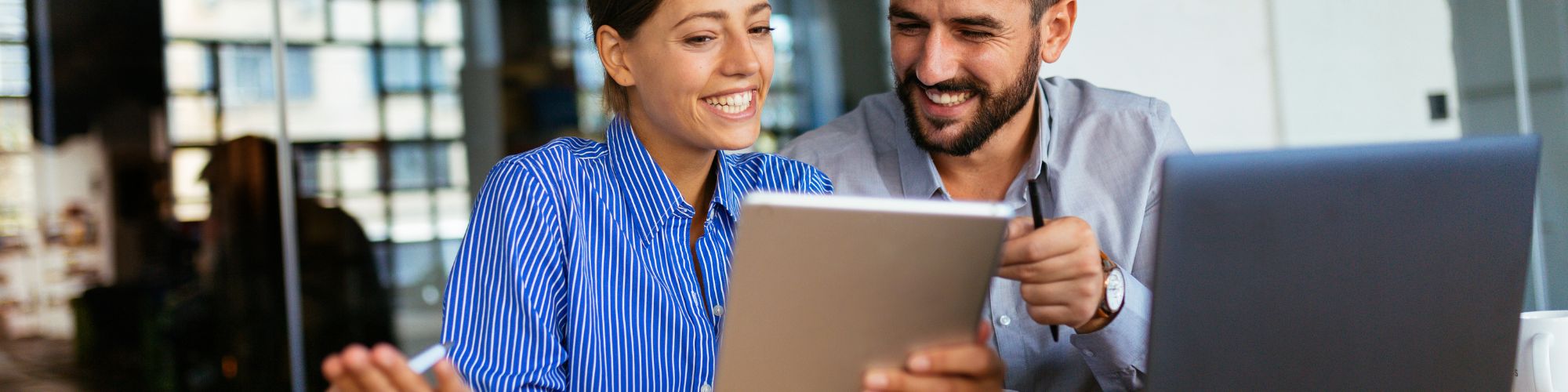 man and woman looking at laptop and tablet