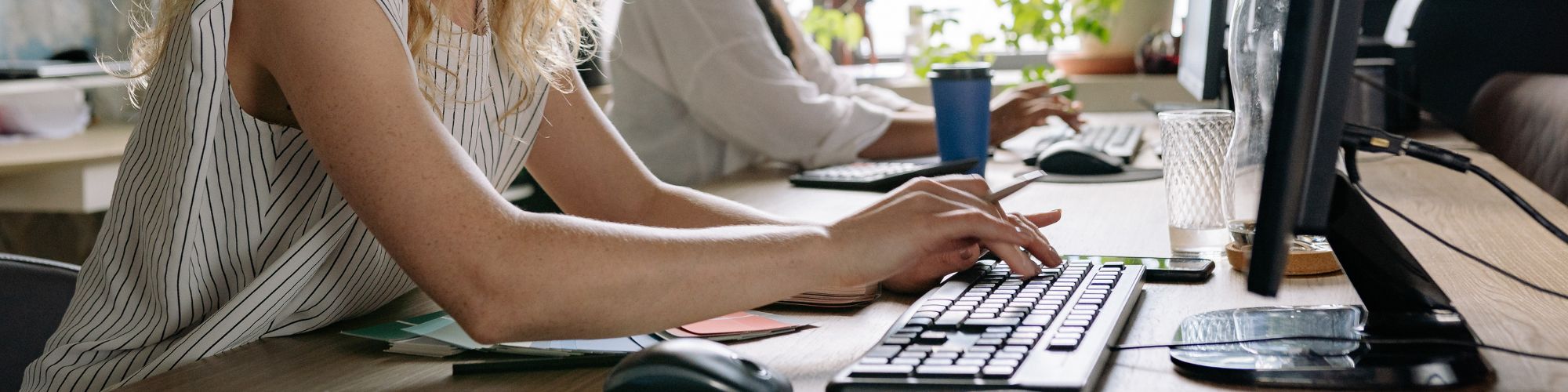 woman working and typing on desktop computer